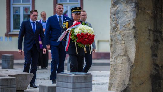 zdjęcie przedstawia mężczyzn z wieńcem