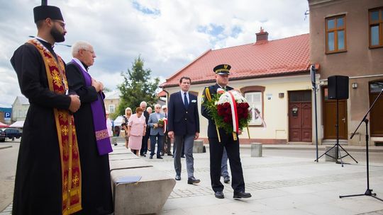 grupa osób składających kwiaty na placu w gorlicach