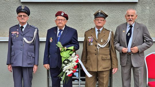 trzech starszych mężczyzn w mundurach wojskowych, jeden w garniturze podczas rocznicy wybuchu wojny