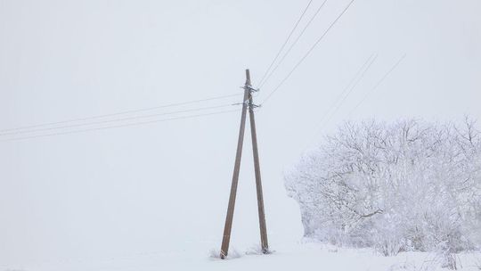 zdjęcie przedstawia słup energetyczny w zimie
