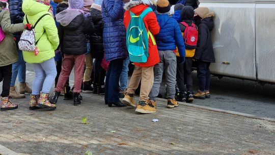 Dzieci z plecakami szkolnymi wsiadające do autobusu na przystanku w Gorlicach