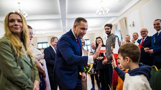 zdjęcie przedstawia mężczyznę przybijającego piątkę dzieciom