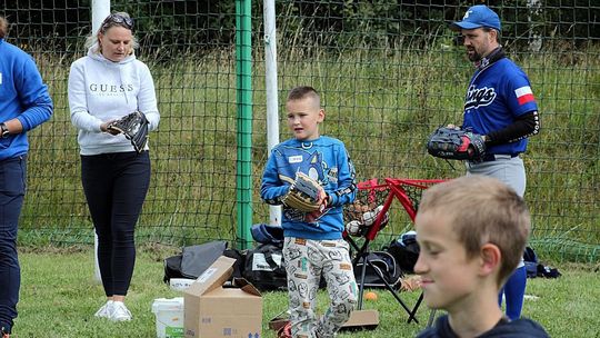 zdjęcie przedstawia osoby, które grają w baseball, trzymają kij i piłki