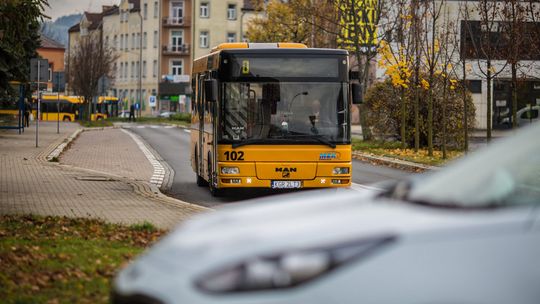 żółty autobus jadący ulicą
