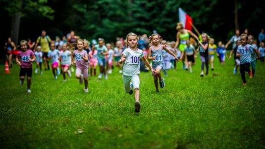 dzieci biegnące przez łąkę