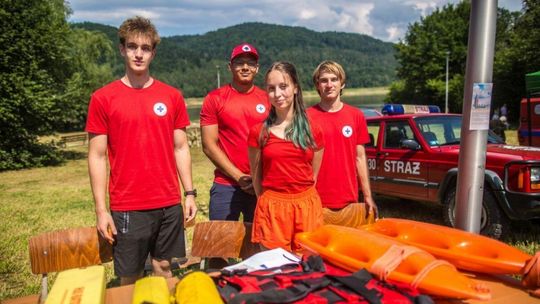 grupa osób w czerwonych koszulkach przy stoliku podczas pikniku nad zbiornikiem klimkówka w beskidzie niskim
