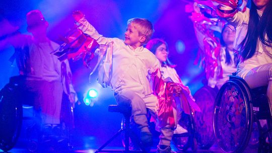 zdjęcie przedstawia dziecko na stołku na scenie domu kultury