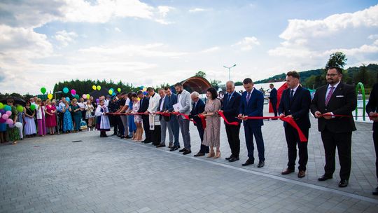 zdjęcie przedstawia grupę osób które przecina wstęgę na basenie