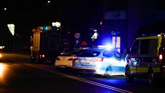 zdjęcie przedstawia policyjny radiowóz stojący na ulicy w nocy