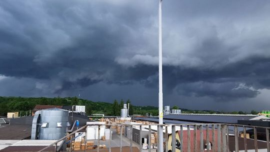 zdjęcie przedstawia ciemne chmury nad zabudowaniami