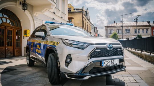 zdjęcie przedstawia samochód straży miejskiej przed ratuszem