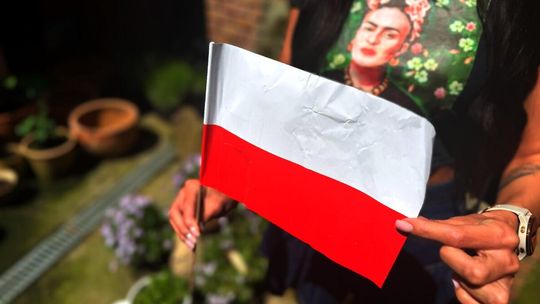zdjęcie przedstawia dziewczynę, która trzyma flagę przed sobą