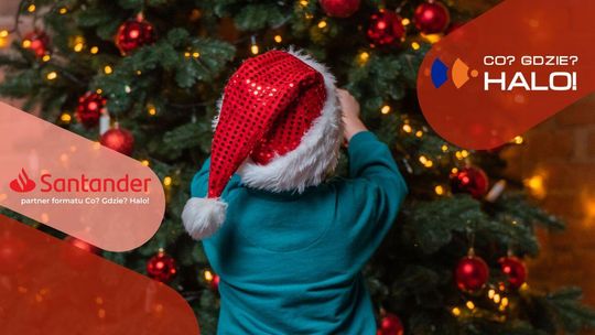 zdjęcie przedstawia dziecko ozdabiające choinke