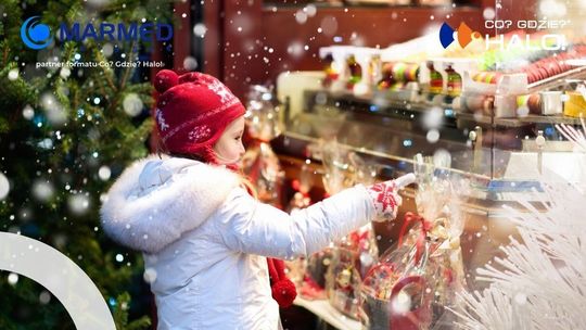 zdjęcie przedstawia dziecko na tle kiermaszu świątecznego