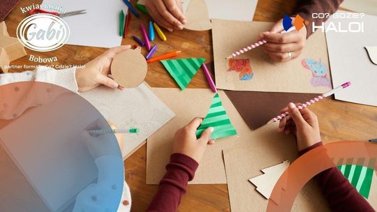 zdjęcie przedstawia dłonie dzieci trzymające ołówki i ozdoby świąteczne