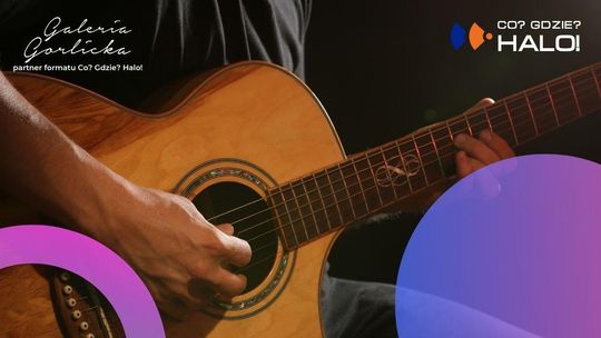 Zdjęcie przedstawia mężczyznę grającego na gitarze