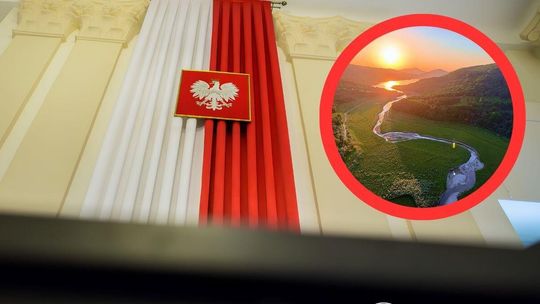 zdjęcie przedstawia biało-czerwoną flagę na ścianie w centrum orzeł w godle