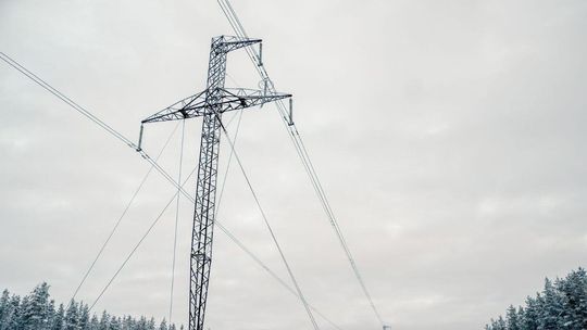 zdjęcie przedstawia słup z liniami energetycznymi w zimie