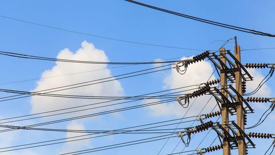 zdjęcie przedstawia słupy energetyczne z rozpiętymi między nimi liniami