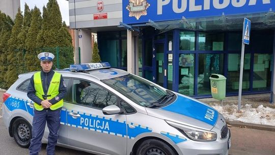 zdjęcie przedstawia policjanta na tle budynku policji