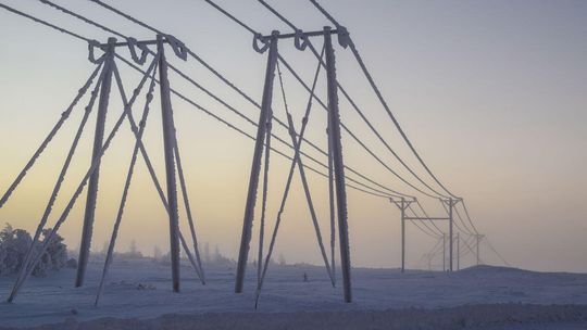 zdjęcie przedstawia słup energetyczny i linie energetyczne oblepione śniegiem