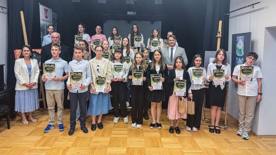 zdjęcie przedstawia grupę osób trzymających dyplomy