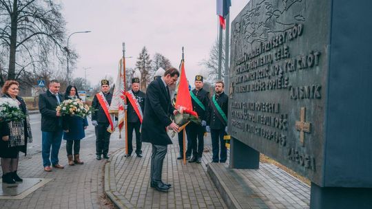 Zdjęcie przedstawia burmistrza składającego wieniec pod pomnikiem