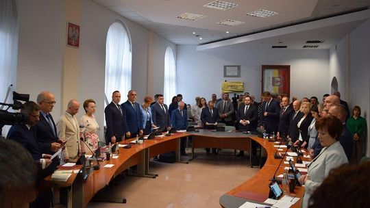 grupa osób stojąca w około stołu