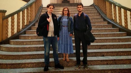 zdjęcie przedstawia dwóch mężczyzn i kobietę na schodach