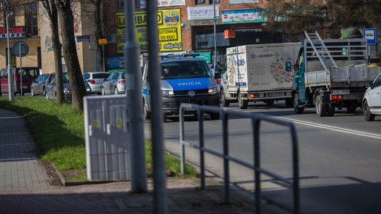 zdjęcie przedstawia radiowóz jadący ulicą w mieście