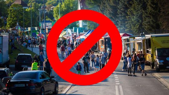 zdjęcie przedstawia czerwone kółko z kreską, w tle zatłoczona ulica i stragany