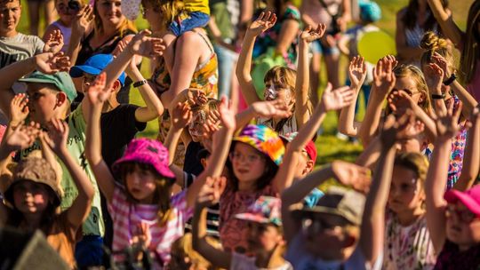 dzieci trzymające ręce do góry podczas zabawy w dniu dziecka