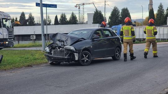 zdjęcie przedstawia rozbitą karoserię samochodu i strażaków wokół pojazdu