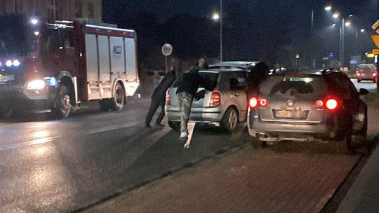 zdjęcie przedstawia dwa samochody na jezdni obok samochód straży pożarnej