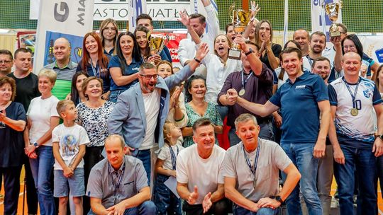 grupa osób z pucharem ciesząca się i pozująca do zdjęcia w hali sportowej w gorlicach