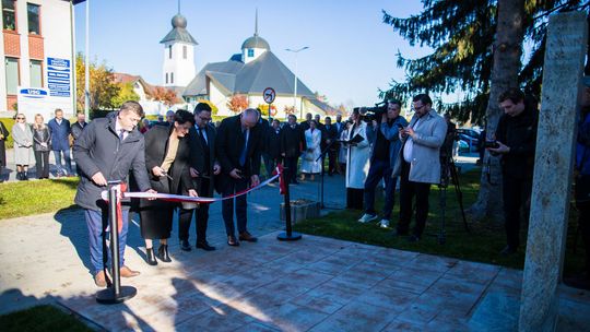 kilka osób przecina wstęgę przed pomnikiem w Gorlicach