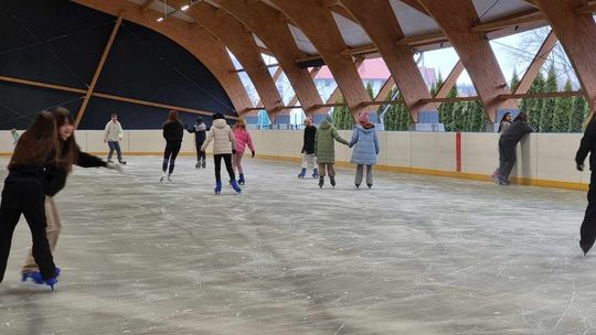 zdjęcie przedstawia ludzi ślizgających się na łyżwach