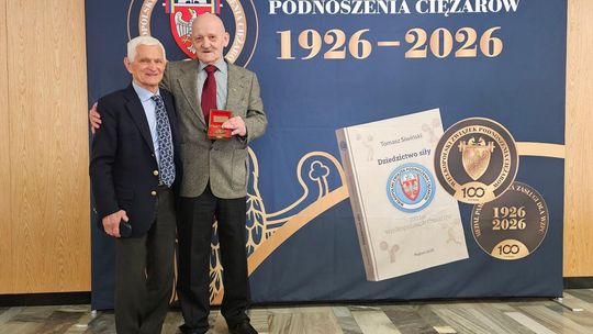 zdjęcie przedstawia dwóch mężczyzn przed ścianką reklamową