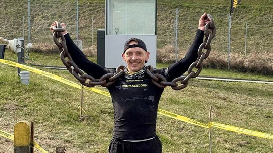 zdjęcie przedstawia mężczyznę trzymającego łańcuch na szyi