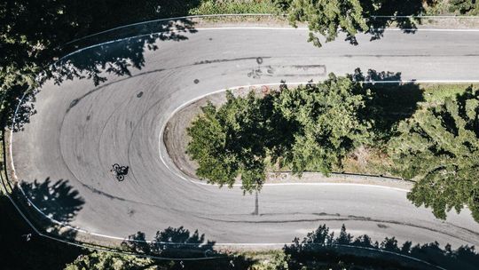 Rowerzysta jadący na krętej drodze przez las