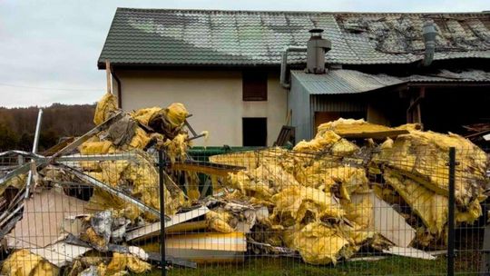 wełna mineralna leżąca na trawie przed budynkiem po pożarze w ropicy górnej