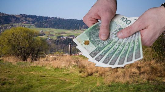 dłonie trzymające banknoty, w tle wzgórza beskidu niskiego