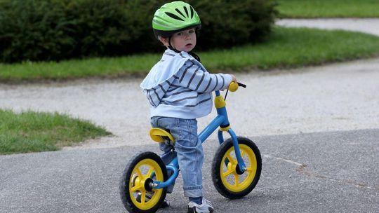 zdjęcie przedstawia dziecko na rowerku