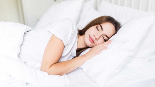 zdjęcie przedstawia kobietę śpiącą w łóżku