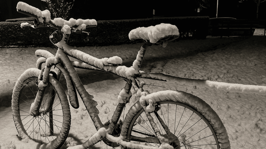 zdjęcie przedstawia rower obsypany śniegiem