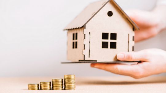 Jak ulga termomodernizacyjna współpracuje z dotacją na okna i jakie odliczenia można uzyskać w PIT? zdjęcie przedstawia makietę domu trzymaną w dłoniach