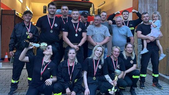 Zdjęcie przedstawia grupę ludzi z medalami