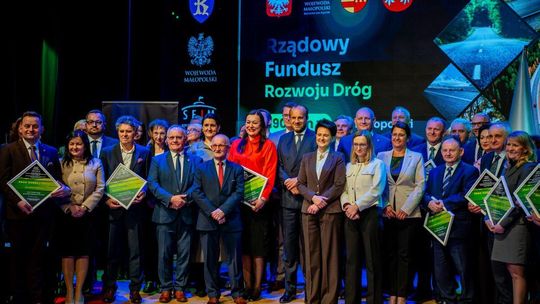 Zdjęcie przedstawia grupę osób na scenie