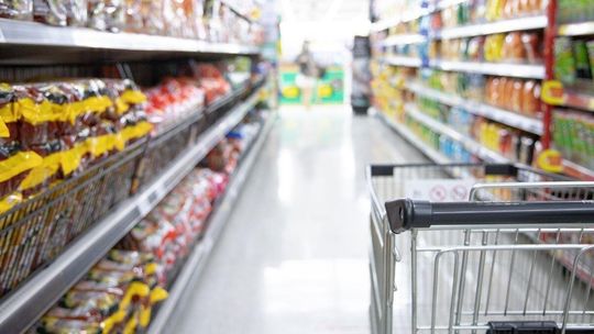 wózek w markecie obok półek sklepowych