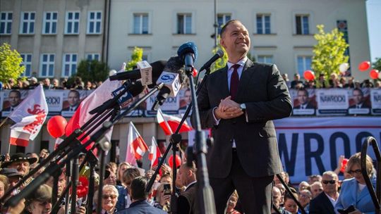 zdjęcie przedstawia mężczyznę przy mikrofonach